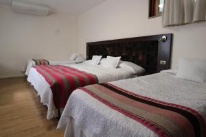 卡拉马阿坦卡拉马酒店的配有衬衫的酒店客房内的两张床