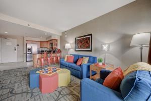 拉斯维加斯Spacious Retro 1 BR Condo with Sphere Views 1 Block from Vegas Strip NO Resort Fees的一间带蓝色沙发的客厅和一间厨房