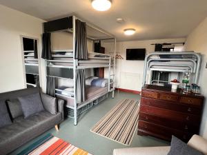 森嫩Lands End Hostel and B&B的一间带双层床和沙发的客厅