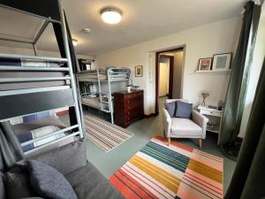 森嫩Lands End Hostel and B&B的带两张双层床和椅子的房间