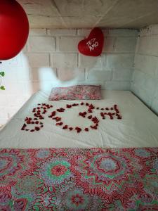 圣贝尔纳多德尔比恩托Cabaña Palmeras del Viento的一张床上有一堆玫瑰花瓣