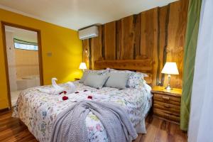普孔Cabañas el Dorado Pucón的一间卧室配有一张带两个天鹅的床