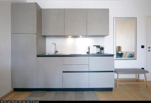罗维尼Val De Laco studio apartments的厨房配有白色橱柜和水槽