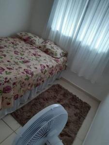 马塞约Casa Aeroporto Maceió Palmeiras的卧室配有床、风扇和地毯。