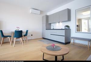 罗维尼Val De Laco studio apartments的一间带桌子的客厅和一间厨房
