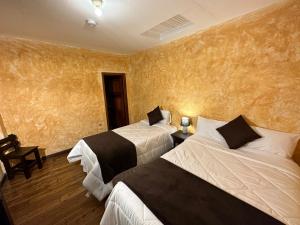 昆卡NASS Central Garden的两张床位于带黄色墙壁的酒店客房