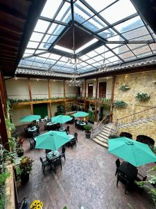 昆卡NASS Central Garden的室内餐厅,配有桌子和绿伞
