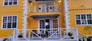 戴蒙德Faith's Villa Tobago的黄色建筑,前面设有阳台