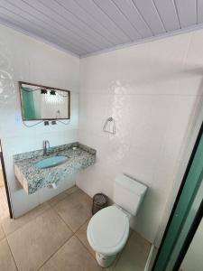 伊达贾伊Residencial Silveira的一间带卫生间、水槽和镜子的浴室