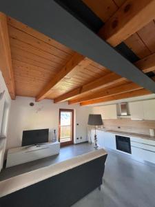 奥斯塔Grazioso appartamento的大型客厅设有木制天花板和窗户。
