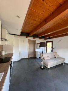 奥斯塔Grazioso appartamento的客厅设有白色沙发和木制天花板