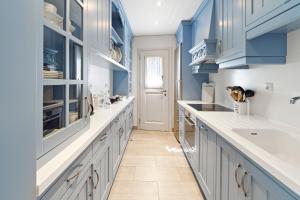 安德罗斯Beachfront Gem in Andros Town的厨房配有蓝色橱柜和白色柜台。