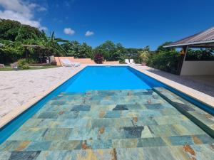 MahinaVilla MONOIHERE的一座带瓷砖地板和房子的游泳池