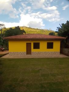 康塞高伊比蒂波卡CASA do CRISTOVAO IBITIPOCA的黄色的房屋,有红色的屋顶