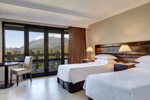 圣卡洛斯-德巴里洛切Arelauquen Lodge, a Tribute Portfolio Hotel的酒店客房设有两张床和一个阳台。