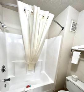 OacomaEcono Lodge Oacoma的浴室配有浴缸和淋浴及窗帘