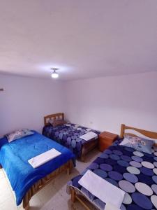 RecuayHacienda Norabuena的配有蓝色床单的客房内的三张床