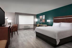 杜兰戈Holiday Inn & Suites Durango Downtown, an IHG Hotel的酒店客房设有一张大床和一张书桌。