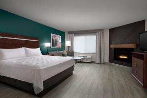 杜兰戈Holiday Inn & Suites Durango Downtown, an IHG Hotel的酒店客房配有一张床和一个壁炉。