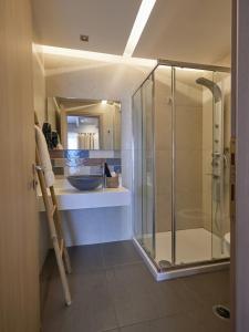 托隆CICADA HOTEL的一间带玻璃淋浴和水槽的浴室