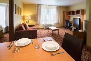 斯科茨Sonesta Simply Suites Phoenix Scottsdale的酒店客房设有桌子和客厅。