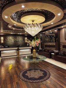 费萨拉巴德Oxygym Hotel Faisalabad的大堂设有玻璃桌和吊灯。