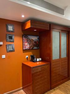 哈费尔巴廷درة سنام للاجنحة الفندقيه المخدومة的一间设有橙色墙壁、柜台和电视的客房