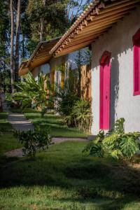 托兰克索Villa Mediterrâneo Trancoso的粉红色门和院子的房子