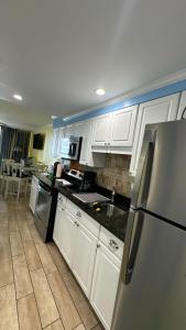 默特尔比奇Ocean Front 53 Steps的厨房配有白色橱柜和不锈钢冰箱
