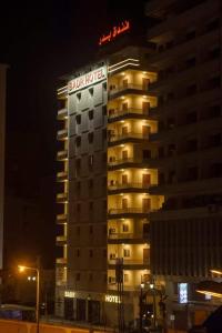 艾斯尤特Badr Hotel Assiut的一座在晚上标有酒店标志的建筑