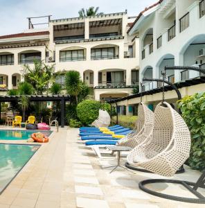 长滩岛长滩岛太阳酒店的一座建筑旁的带游泳池和椅子的酒店