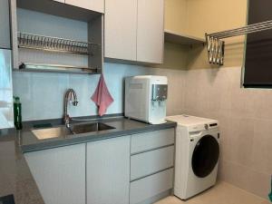 八打灵再也Greenfield Residence Sunway Subang 10 Pax 3R2B with Internet的厨房配有水槽和洗衣机