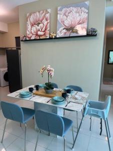 八打灵再也Greenfield Residence Sunway Subang 10 Pax 3R2B with Internet的一张带蓝色椅子和鲜花的餐桌