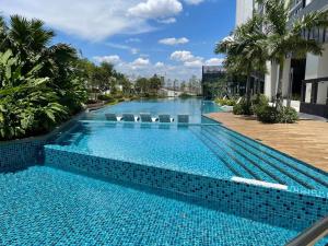 八打灵再也Greenfield Residence Sunway Subang 10 Pax 3R2B with Internet的一个带椅子和棕榈树的大型游泳池