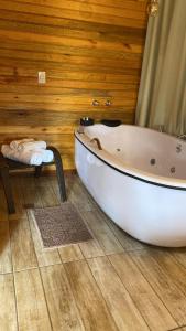 蒙特韦尔迪Chalés Canto da Serra的木墙客房内的白色浴缸
