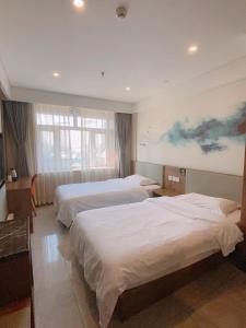 房山区比邻酒店(北京房山区良乡医院店)的酒店客房设有两张床,墙上挂有绘画作品