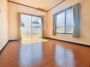 AmakusaLit 天草的一间空房间,铺有硬木地板,设有两个窗户