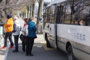 松本富卡式艘酒店的一群人等着上公共汽车