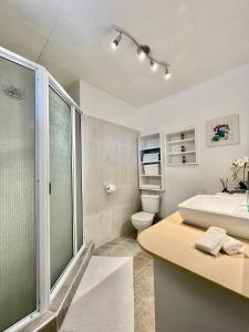 普纳奥亚Tiaki Guesthouse - Cozy Modern Studio - 5min drive from the beach and Punaauia center的带淋浴、盥洗盆和卫生间的浴室