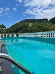 康提Bellwood Hills Resort & Spa的一座大游泳池,后面是一座山