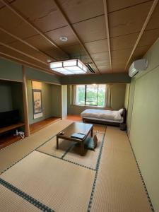 Kannamiファスティングホテル海の杜的客厅配有桌子和床。