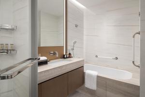 广州广州雅诗阁琶洲服务公寓的一间带水槽、浴缸和镜子的浴室