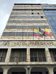 昆卡Hotel Presidente by NASS的上面有两面旗帜的建筑