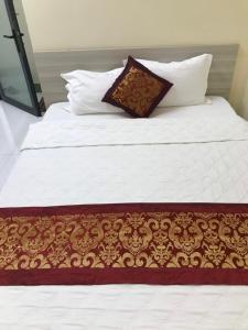 Ấp Tháp MườiKHÁCH SẠN NGUYỄN LONG的白色的床、棕色和白色的毯子和枕头