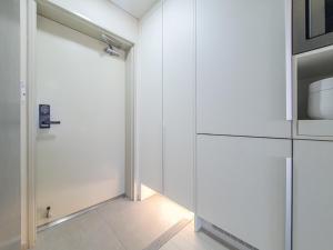 济州市Jeju Centerpoint N Residence的一间白色的厨房,配有门和微波炉