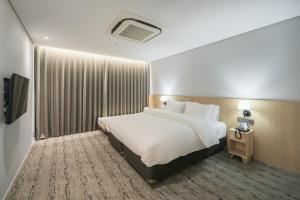 仁川市Aank Hotel Incheon Guwol的酒店客房,配有床和电视