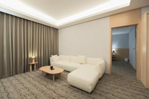 仁川市Aank Hotel Incheon Guwol的客厅配有白色的沙发和桌子