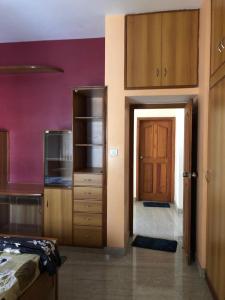 迈索尔Mahagiri Nest的一间设有一张床的客房和一间带门的厨房