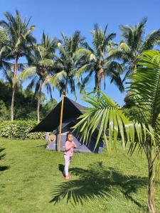 比亚米尔港Campo Duro Ecolodge的站在棕榈树帐篷前的一名幼儿