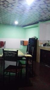 卡卢特勒Kuchi Villa的厨房配有桌椅和绿色的墙壁